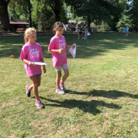 Two Girls on the Run participants work together in pink shirts outdoor 